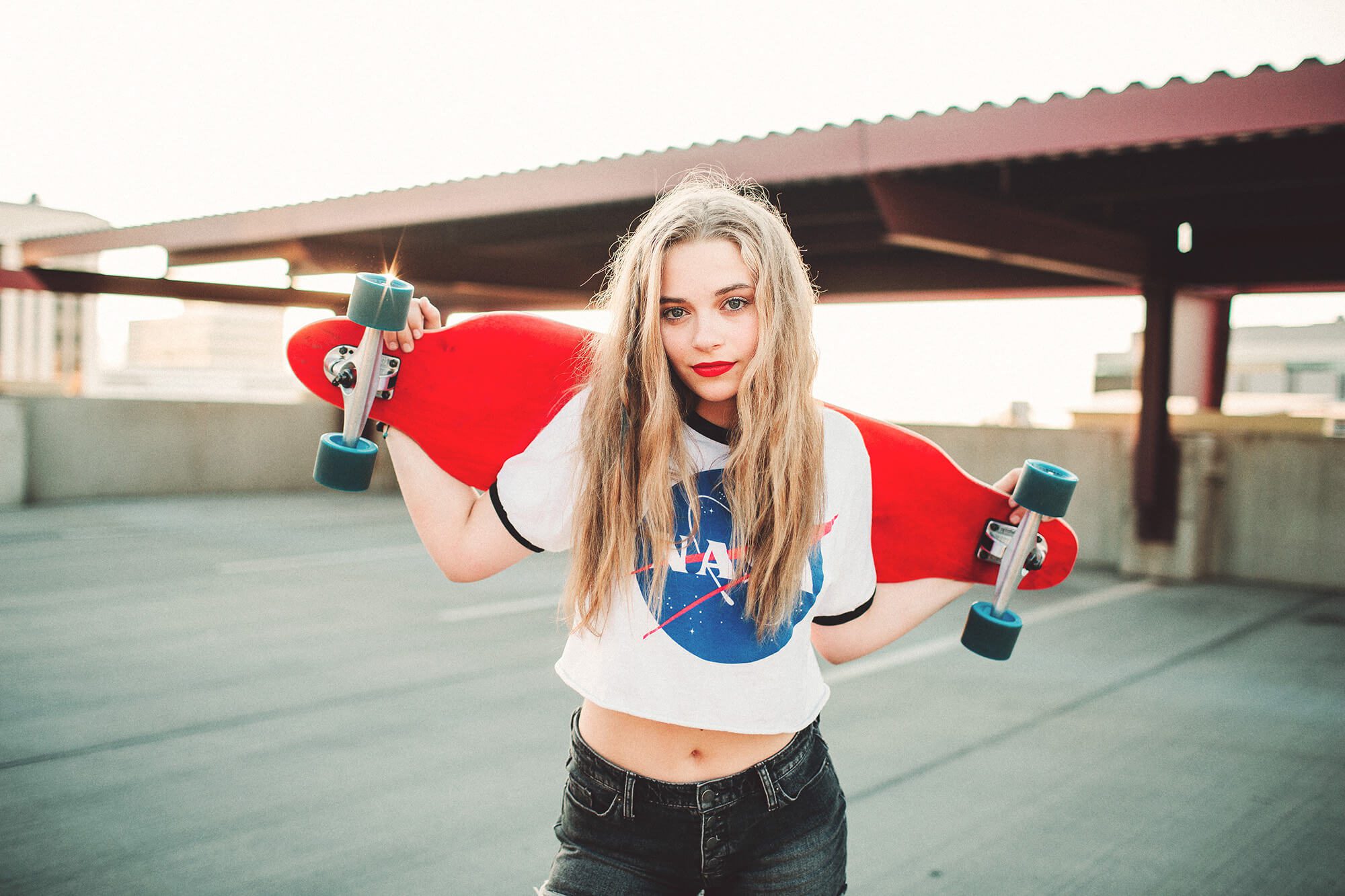 A senior girl and her skateboard atop a Tucson rooftop at sunset